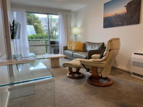 a living room with a chair and a couch at Belvedere Apartments in Wanaka