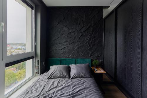 a bedroom with a bed and a black wall at Oceanview Apartment baltyk Gdynia in Gdynia