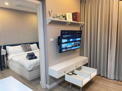 a small bedroom with a bed and a flat screen tv at C sky Seaview @The Blu X in Bangsaen