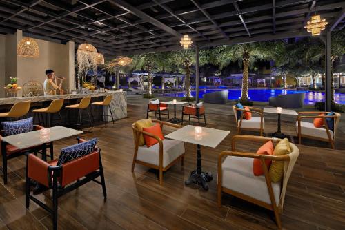 a restaurant with tables and chairs and a bar at Wyndham Hoi An Royal Beachfront Resort & Villas in Hoi An