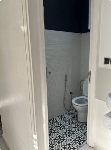 a bathroom with a white toilet and a black and white tile floor at Chambre à Agdal Rabat dans un appartement partagé in Rabat