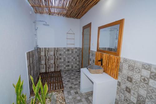 uma casa de banho com um WC, um lavatório e um espelho. em Govinda villa em Nusa Penida