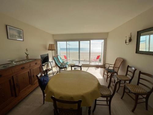 un salon avec une table et des chaises et un balcon dans l'établissement Appartement T3 avec balcon, garage et cuisine équipée - FR-1-197-417, à Les Sables-dʼOlonne
