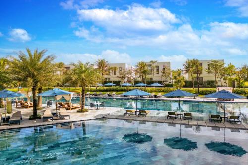 a pool at a resort with chairs and umbrellas at Wyndham Hoi An Royal Beachfront Resort & Villas in Hoi An