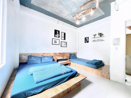- une chambre avec un lit bleu et un cadre de lit en bois dans l'établissement Domik Homestay - Cát Bà, à Cat Ba