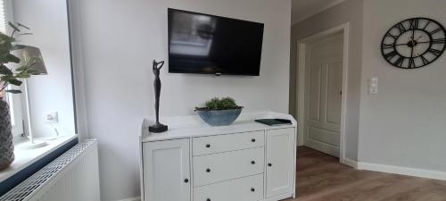 a white cabinet with a tv on a wall at Ferienwohnung am Bibelgarten Julia in Werlte