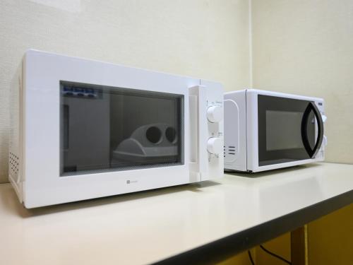 two microwaves sitting on top of a counter at Hotel Green Park Suzuka in Suzuka