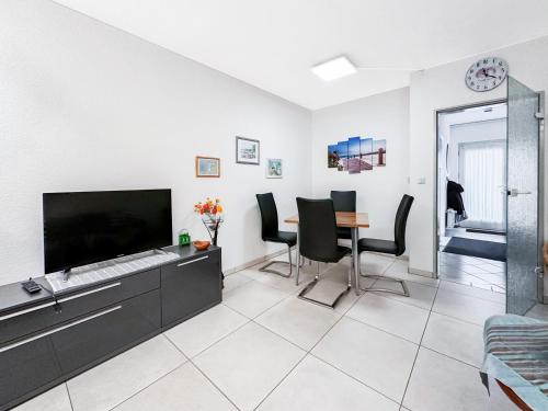 a living room with a tv and a table and chairs at Reihenendhaus Marina Sol in Dahme
