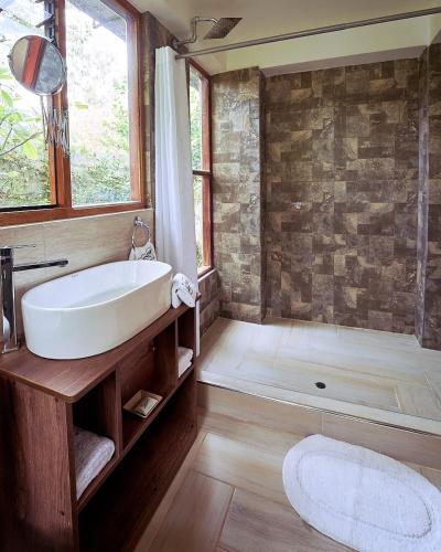 a bathroom with a white sink and a shower at Spirit Of The River Lodge in Cusco