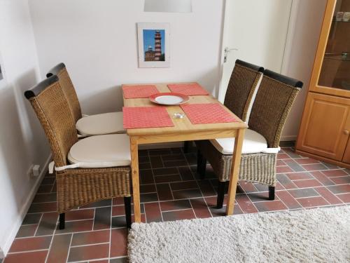 stół jadalny z krzesłami i talerzem w obiekcie Rosa Canina, W3 w mieście Kellenhusen