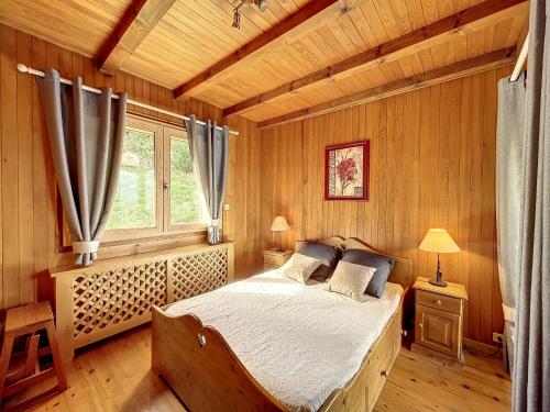 a bedroom with a bed in a wooden room at Chalet Combloux, 5 pièces, 8 personnes - FR-1-560-32 in Combloux