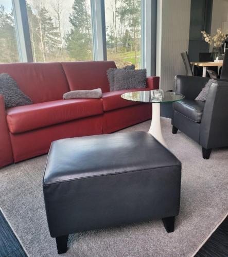 a living room with a red couch and a table and chairs at Appartment Seeblick 4 1OG Grundbelegung 4 Pers in Elsterheide
