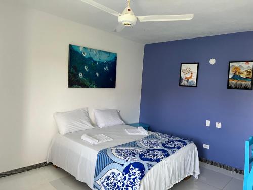 1 dormitorio con 1 cama con pared azul en Hotel brisa mar, en Las Terrenas