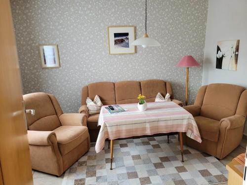 uma sala de estar com um sofá e duas cadeiras e uma mesa em Ferienhof Manowski Nr1 em Hinrichsdorf