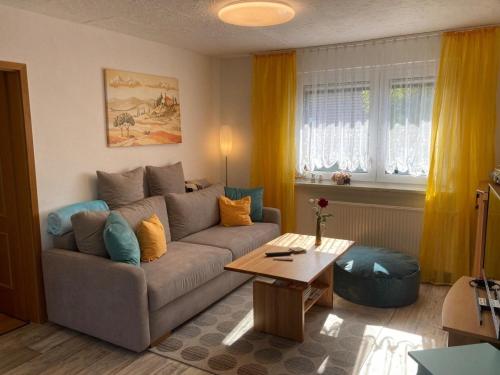 ein Wohnzimmer mit einem Sofa und einem Tisch in der Unterkunft Ferienwohnung Blessbergblick in Eisfeld