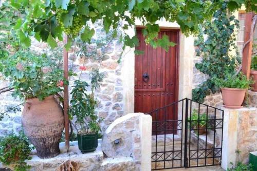 a house with a red door and some plants at Ferienhaus in Pefki mit Terrasse und Grill in Pévkoi