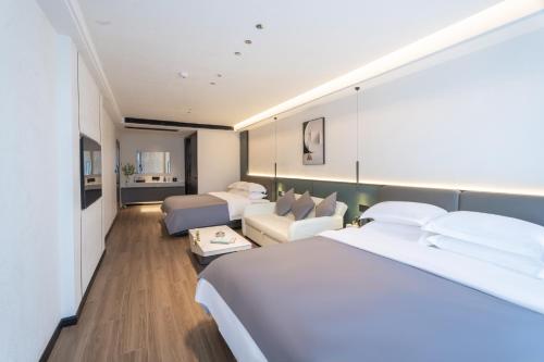 una camera d'albergo con due letti e un divano di Shanming Boutique Homestay a Fenghuang