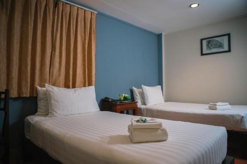 a hotel room with two beds and a blue wall at Pakse hotel & Restaurant in Pakse