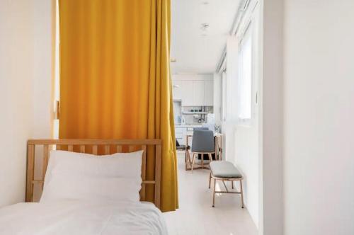 een slaapkamer met een bed en een oranje gordijn bij ZiiP HILLS 3 in Seoul
