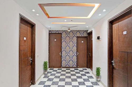 a hallway with wooden doors and a checkered floor at The Bed And Rock Kalkaji in New Delhi