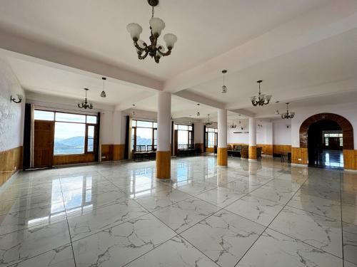 a large room with a large marble floor and a chandelier at Hawk Eye Resort in Shimla