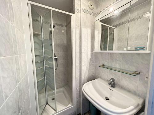 La salle de bains blanche est pourvue d'une douche et d'un lavabo. dans l'établissement Appartement Jullouville, 2 pièces, 4 personnes - FR-1-361-360, à Jullouville