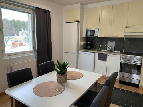 a kitchen with a white table with chairs and a table at 2BR big Apartment, free parking in the street, Allitie 8 in Oulu