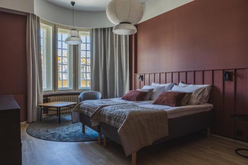 1 dormitorio con 1 cama grande y paredes rojas en Ineon Hotel, en Turku