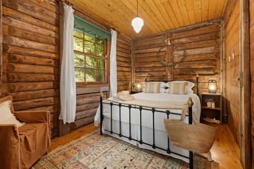 a bedroom with a bed in a log cabin at Restdown Kangaroo Valley in Barrengarry