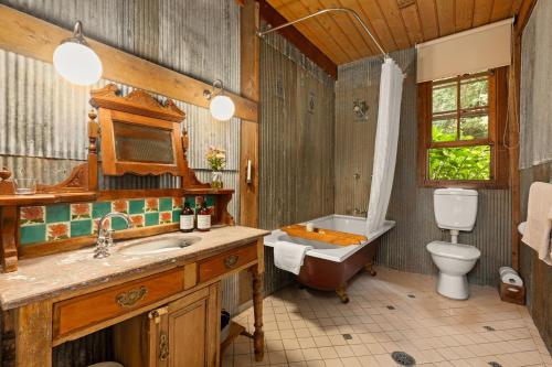 a bathroom with a tub and a toilet and a sink at Restdown Kangaroo Valley in Barrengarry