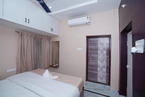 a bedroom with a bed and a window at Katyayani Serenity - Your Premium Homestay in Bhadrāchalam