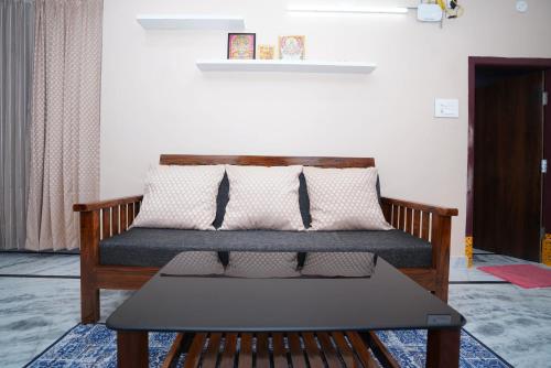 a bed with pillows and a table in a room at Katyayani Serenity - Your Premium Homestay in Bhadrāchalam