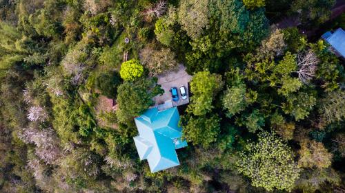 an aerial view of a house with a blue umbrella at Hilton Cloud Resort in Wayanad