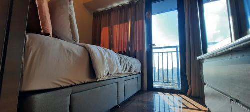 マニラにあるAIR Luxury Makati CBD with balconyのバルコニー付きの客室のベッド1台分です。