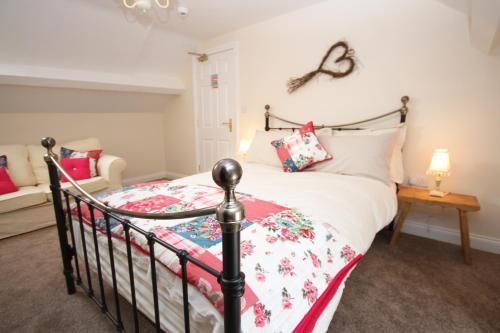 a bedroom with a bed with a red and white quilt at The Forge in Whitby