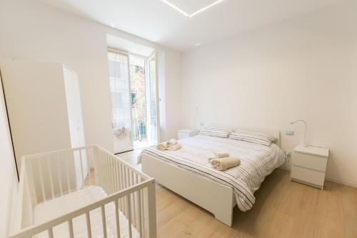 a white bedroom with a bed and a staircase at Il Giglio - Free Parking in Como