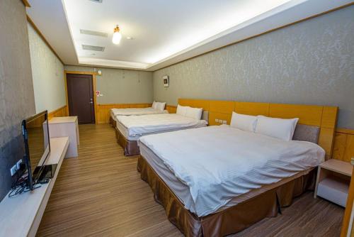 een hotelkamer met 2 bedden en een flatscreen-tv bij Dragon Manor Resort in Renai