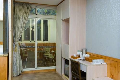 een keuken met een wastafel en een tafel met stoelen bij Dragon Manor Resort in Renai