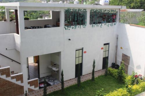 a white house with a toilet in the yard at El Rincón Preferido in Papantla de Olarte