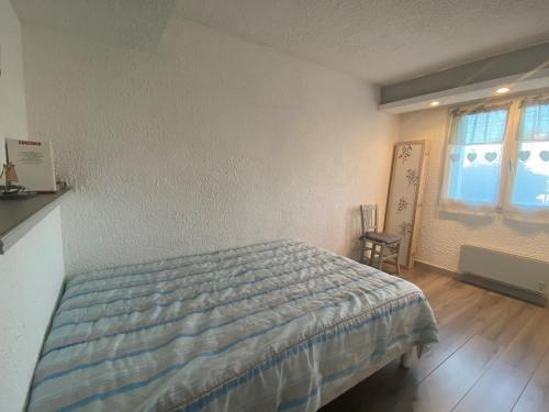 une chambre avec un lit et une fenêtre dans l'établissement Appartement 2 pièces avec terrasse privative, animaux admis - FR-1-487-332, à Cabourg