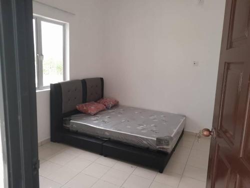 a bed sitting in a room next to a window at Panorama Indah Homestay in Sungai Besar