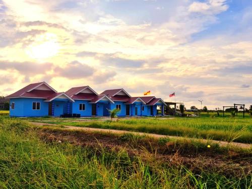 une rangée de maisons au milieu d'un champ dans l'établissement Panorama Indah Homestay, à Sungai Besar