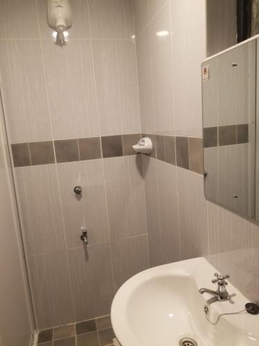 內羅畢的住宿－7 Days Holiday Inn，一间带水槽和镜子的浴室