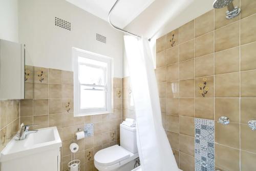 ein Bad mit einem WC und einem Waschbecken in der Unterkunft Hall St - Hideaway in the Heart of Bondi Beach in Sydney