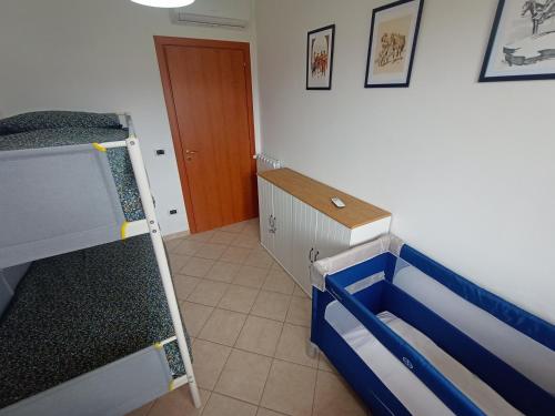 a room with two bunk beds and a wooden door at Degli Angioini Holiday Home in Caulonia Marina