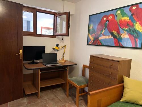 een kamer met een bureau, een computer en een bed bij Relax House & Garden in Santa Luria