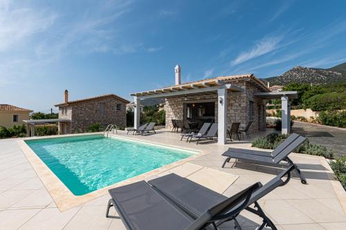 a villa with a swimming pool and a house at Costa Bianca Villas in Koilás