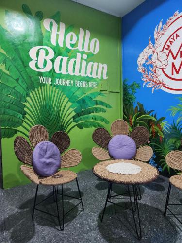deux chaises devant un mur avec un signe bonjour bahrain dans l'établissement Maya Suites Badian powered by Cocotel, à Badian