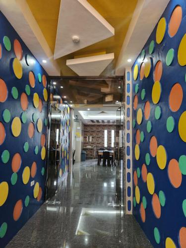 un couloir avec un mur recouvert de points de polka dans l'établissement Maya Suites Badian powered by Cocotel, à Badian