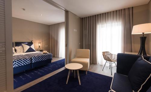 a hotel room with a bed and a chair at Hotel Casa Hintze Ribeiro in Ponta Delgada